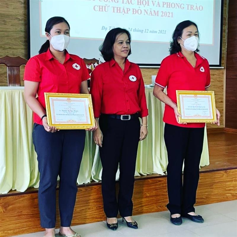 Bà Phan Thị Hồng Loan (giữa) Chủ tịch Hội Chữ thập đỏ huyện trao giấy khen cho các cá nhân có nhiều thành tích xuất sắc trong công tác Hội năm 2021