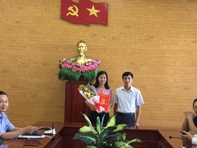 Đồng chí Nguyễn Mạnh Việt, Phó Bí thư Thường trực Huyện ủy trao quyết định, tặng hoa cho đồng chí Nguyễn Thị Thúy
