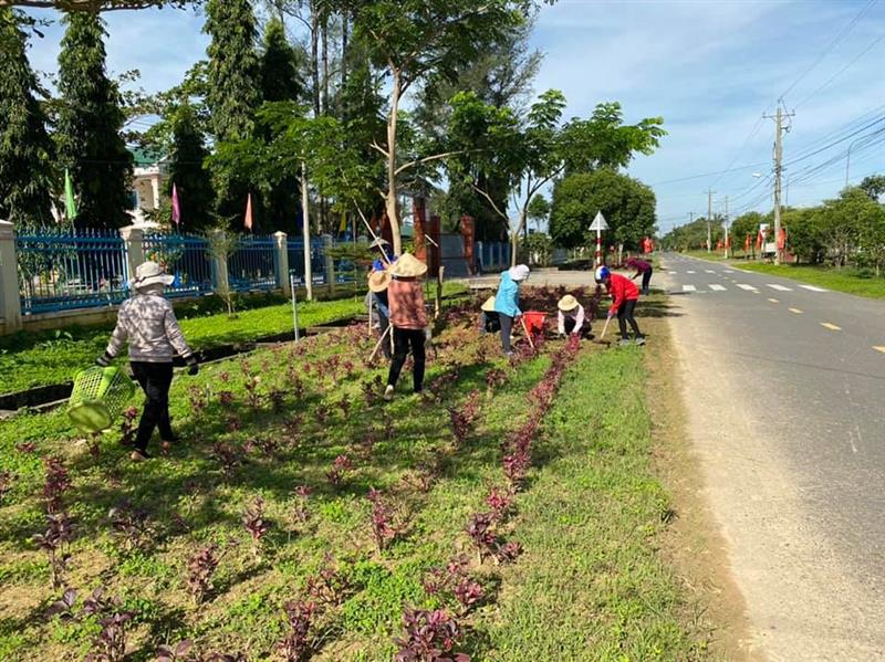Chị em phụ nữ tham gia trồng hoa ven đường tạo cảnh quan xanh sạch đep