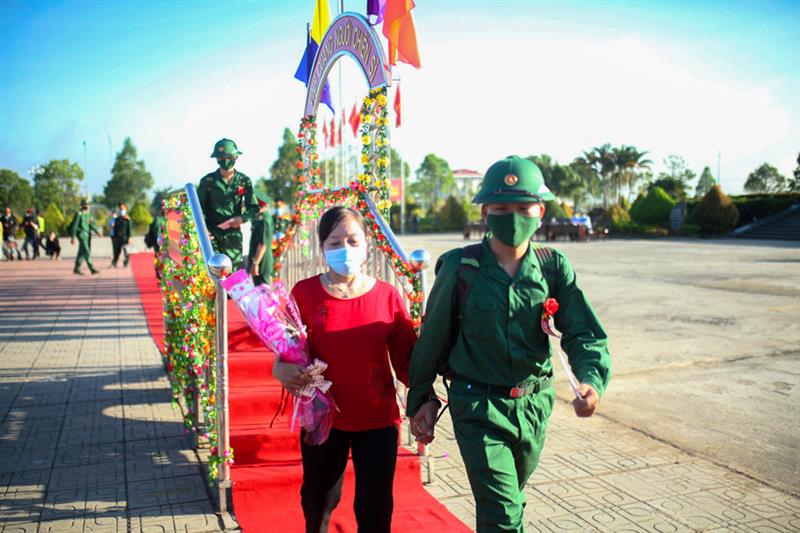 Các tân binh nắm tay người thân bước qua cầu vinh quang để tiến ra xe, lên đường nhập ngũ