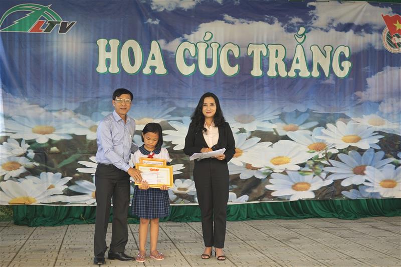 Đồng chí Nguyễn Mạnh Việt, Phó Bí thư Thường trực Huyện ủy trao học bổng của hội khuyến học và quà cho em Bế Tuyết Như
