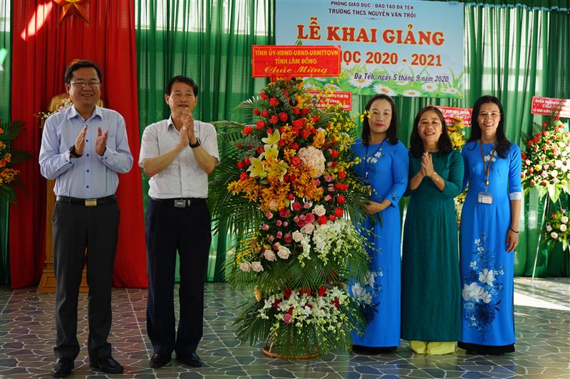 Đ/c Nguyễn Trọng Ánh Đông và lãnh đạo huyện Đạ Tẻh tặng hoa chúc mừng thầy và trò trường THCS Nguyễn Văn Trỗi