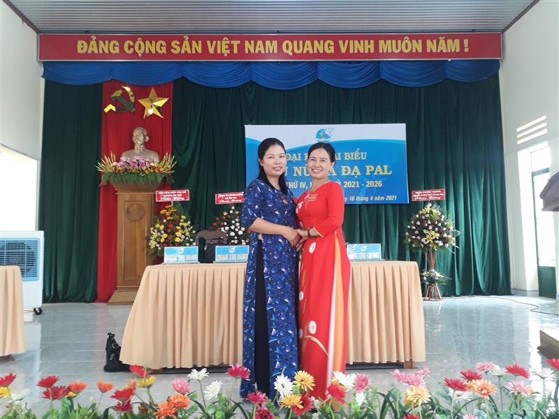 Chị Bùi Thị Thanh Hà mặc áo dài đỏ đứng bên cạnh chị Phạm Thị Oanh - Chủ tịch Hội LHPN xã Đạ Pal