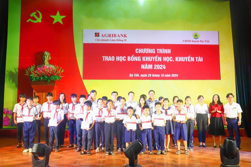 Đại diện lãnh đạo huyện Đạ Tẻh và Ngân hàng Agribank trao học bổng cho các em học sinh.